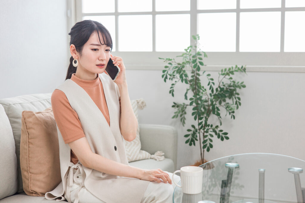 電話で待たされる女性
